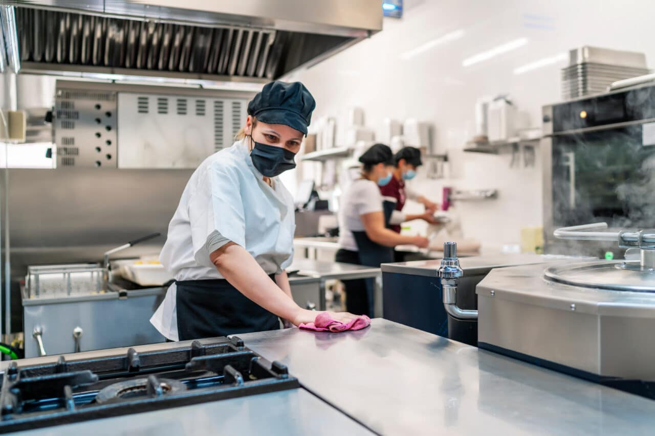 female cook cleaning her kitchen after work